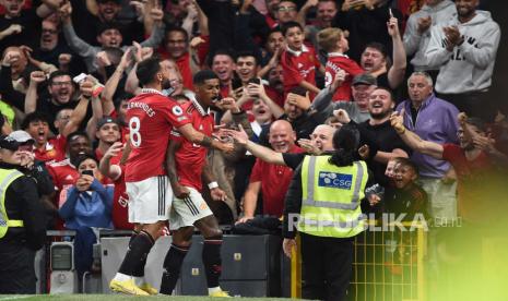 Marcus Rashford dari Manchester United (kanan) merayakan dengan rekan setimnya Bruno Fernandes (kiri) di dekat tribun setelah mencetak gol selama pertandingan sepak bola Liga Premier Inggris antara Manchester United dan Liverpool FC di Manchester, Inggris, 22 Agustus 2022.