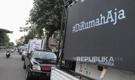 Pekerja memasang terpal pada layar monitor iklan imbauan masyarakat di Baciro, DI Yogyakarta, Selasa (24/3/2020). Badan Penanggulangan Bencana Daerah (BPBD) DIY bekerja sama dengan Pekerja Event Jogja melakukan sosialisasi pencegahan penyebaran virus Corona atau COVID-19 dengan membuat monitor raksasa dan dibawa berkeliling kota Yogyakarta