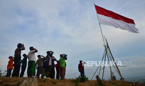 Sejumlah warga hormat bendera saat mengikuti pengibaran bendera Merah Putih di bukit Cangkraman, Pegunungan Patiayam, Desa Terban, Kudus, Jawa Tengah, Kamis (28/10/2021). Pengibaran dan penghormatan bendera Merah Putih berukuran 5 x 9,5 meter di atas bukit setinggi kurang lebih 350 meter di atas permukaan laut itu untuk memperingati Hari Sumpah Pemuda sekaligus meningkatkan rasa nasionalisme. 