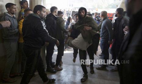 A Palestinian carries a wounded person (C) inside Nasser Hospital in Khan Yunis, southern Gaza Strip, 03 December 2023, following an Israeli air strike. Israeli forces resumed military strikes on Gaza after a week-long truce expired on 01 December. More than 15,000 Palestinians and at least 1,200 Israelis have been killed, according to the Gaza Government media office and the Israel Defense Forces (IDF), since Hamas militants launched an attack against Israel from the Gaza Strip on 07 October, and the Israeli operations in Gaza and the West Bank which followed it.  