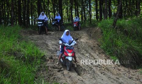 Pelajar mengendarai sepeda motor melintasi jalan tanah di kawasan hutan Dusun Kalitengah, Rejosari, Kradenan, Grobogan, Jawa Tengah, Selasa (7/3/2023). Direktur Hubungan Kelembagaan PT Jasa Raharja Munadi Herlambang mengajak semua pihak dari berbagai elemen masyarakat untuk bersama-sama mencegah terjadinya kecelakaan lalu lintas menimpa kalangan pelajar. 