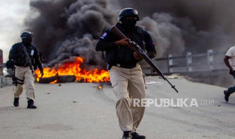 Petugas polisi menghadapi pengunjuk rasa selama hari demonstrasi, di Cap-Haitien, Haiti, 22 Juli 2021. Demonstran menuntut keadilan bagi Jovenel Moise, mantan presiden Haiti yang dibunuh pada 07 Juli, mendirikan api unggun dan barikade di berbagai titik kota, di utara negara itu, tempat presiden terbaru lahir. Pendukung setia Jovenel tidak ingin pemakamannya, yang dijadwalkan Jumat, berlangsung sampai pembunuhnya dihukum. Saat ini, 26 orang telah ditangkap karena diduga terlibat dalam kasus tersebut.