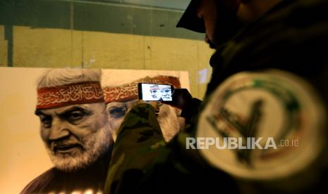 Seorang anggota Pasukan Mobilisasi Populer Syiah Irak di lokasi serangan pesawat tak berawak AS yang menewaskan jenderal Iran Qasem Soleimani dan Abu Mahdi al-Muhandis, wakil pemimpin milisi Pasukan Mobilisasi Populer di jalan utama Bandara internasional Baghdad di Baghdad, Irak , 02 Januari 2021. Ratusan pendukung Pasukan Mobilisasi Populer Syiah Irak berkumpul di lokasi serangan pesawat tak berawak AS pada peringatan pertama pembunuhan komandan milisi Irak Abu Mahdi al-Muhandis dan Qasem Soleimani, kepala Revolusi Islam Iran Pasukan Quds elit Korps Pengawal, dan delapan lainnya di bandara internasional Baghdad pada 03 Januari 2020.