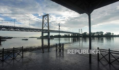 Sebuah perahu bermesin (klotok) melintas di bawah Jembatan Barito di kawasan wisata tepi Sungai Barito, Kabupaten Barito Kuala, Kalimantan Selatan, Sabtu (13/6/2020). Wisata tepi Sungai Barito dengan pemandangan salah satu jembatan terpanjang di Indonesia tersebut menjadi pilihan warga menikmati akhir pekan