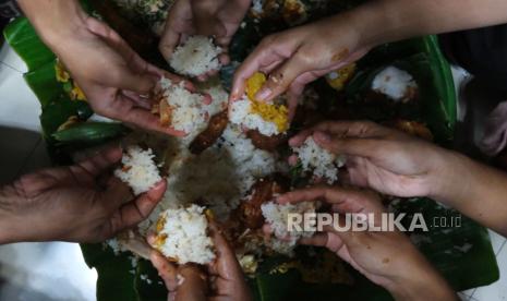 Umat Islam makan bersama dalam satu wadah dalam tradisi Megibung.