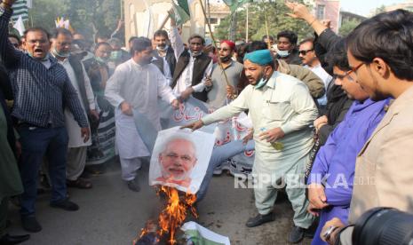 Orang-orang membakar foto Perdana Menteri India Narendra Modi selama protes untuk menunjukkan solidaritas dengan warga Kashmir yang tinggal di Kashmir yang dikelola oleh India pada Hari Hak Asasi Manusia Internasional di Hyderabad, Pakistan, 10 Desember 2020. Demonstran menuntut diakhirinya pemerintahan India di wilayah tersebut dan penyelesaian sengketa menurut keinginan Kashmir dan resolusi PBB. Kashmir, wilayah Himalaya yang mayoritas Muslim yang terbagi antara dua tetangga bersenjata nuklir, telah memicu dua perang di antara mereka sejak kemerdekaan mereka dari Inggris pada tahun 1947.