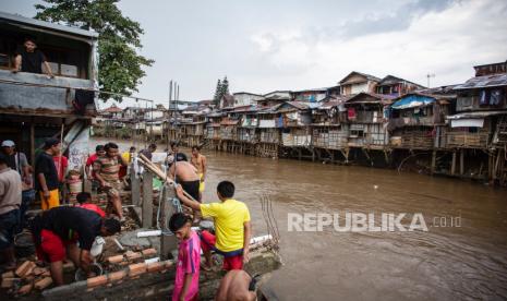 Sejumlah warga membangun sarana MCK (mandi, cuci, kakus) di bantaran Sungai Ciliwung, Manggarai, Jakarta, Ahad (7/3/2021). Wakil Gubernur DKI Jakarta Ahmad Riza Patria mengatakan pembebasan lahan untuk normalisasi Sungai Ciliwung membutuhkan anggaran sebesar Rp 5 triliun. 