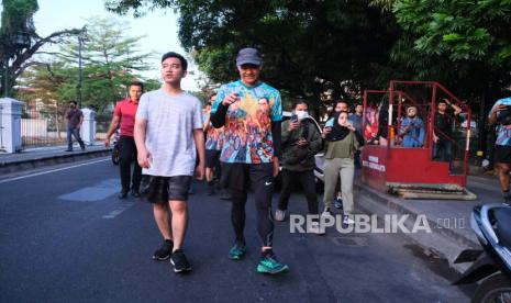 Gubernur Jawa Tengah Ganjar Pranowo bersama Wali Kota Solo Gibran Rakabuming Raka berjalan santai bersama di Kota Solo, Sabtu (5/8/2023). 