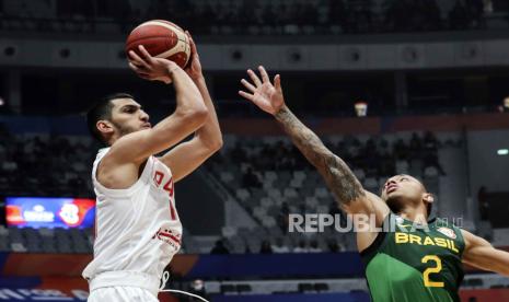 Piter Girgoorian dari Iran (kiri) of mencoba melewati pebasket Brasil Yago Santos (kanan) pada laga Piala Dunia Basket FIBA 2023 di Jakarta, Rabu Sabtu (26/8/2023).