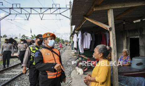 Petugas PT KAI Daop 1 Jakarta berbincang dengan warga saat sosialisasi dalam rangka penertiban bangunan liar di sekitar lintasan kereta api di Stasiun Ancol hingga Stasiun Tanjung Priok, Jakarta. PT KAI menertibkan bangunan semipermanen yang ada di samping rel kereta dekat JIS.