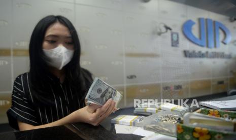 Karyawan menghitung mata uang dollar AS di gerai penukaran mata uang asing VIP (Valuta Inti Prima) Money Changer, Jakarta, Selasa (17/10/2023). Nilai tukar (kurs) rupiah ditutup menguat tipis 5 poin ke level Rp15.716 per dollar AS. Sebelumnya rupiah sempat melemah hingga tembus Rp15.721 per dollar AS.