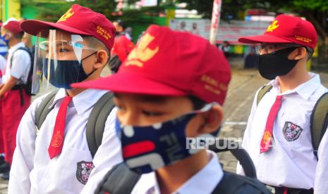 Siswa kelas VII SMPN 1 Kota Jambi mengenakan masker dan pelindung wajah sebelum memasuki kelas pada hari pertama sekolah Tahun Pelajaran 2020/2021 di Jambi, Senin (13/7/2020). Pandemi Covid-19 membuat anak rentan mengalami masalah pemenuhan gizi, bosan di rumah, dan rentan mengalami kekerasan dalam rumah tangga. 