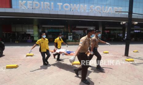 Petugas membawa tandu berisi korban saat simulasi tanggap bencana gempa bumi di salah satu pusat perbelanjaan di Kota Kediri, Jawa Timur, Kamis (16/11/2023). Simulasi yang diikuti oleh Badan Penagggulangan Bencana Daerah (BPBD), Palang Merah Indonesia (PMI), dan karyawan pusat perbelanjaan tersebut sebagai upaya melatih kesiapsiagaan dan evakuasi apabila terjadi gempa bumi. 