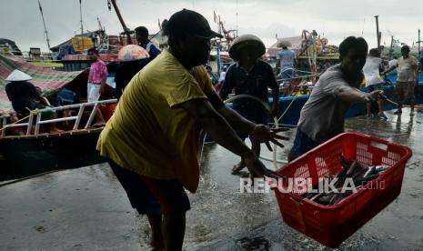 Pekerja mengangkut keranjang ikan di dermaga Tempat Pelelangan Ikan (TPI) Tumumpa, Manado, Sulawesi Utara, Jumat (28/5/2021). 