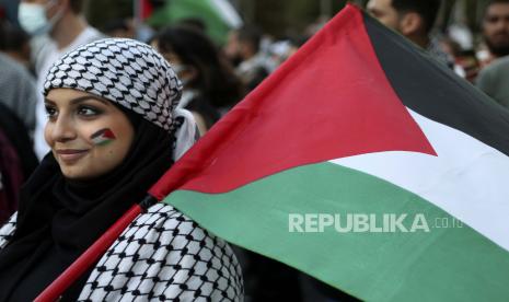  Seorang warga Palestina yang tinggal di Lebanon memegang bendera Palestina saat unjuk rasa untuk mendukung warga Palestina, di Beirut, Lebanon, Selasa, 18 Mei 2021.