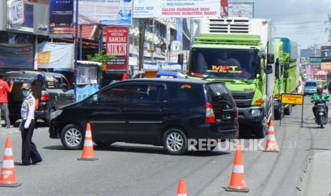 Petugas Dishub meminta kendaraan untuk berputar balik karena tidak berkepentingan saat ingin memasuki Kota Bukittinggi di Simpang Jambu Air, Kabupaten Agam, Sumatera Barat, Sabtu (9/5/2020). Selama Pembatasan Sosial Berskala Besar (PSBB) tahap dua hingga 29 mei 2020, Pemkot Bukittinggi memperketat akses masuk ke kota Jam Gadang itu dengan melarang masuk kendaraan kecuali bagi kendaraan sembako, angkutan Bahan Bakar Minyak (BBM), ambulans dan kendaraan dinas dengan memperlihatkan surat tugas