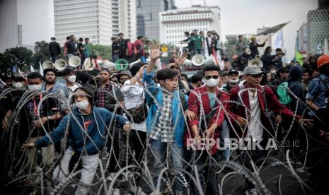 Massa aksi berusaha menembus kawat berduri saat aksi demonstrasi menolak kenaikan harga bahan bakar minyak (BBM) di kawasan Patung Kuda, Jakarta, Selasa (13/9/2022). Dalam aksi tersebut sejumlah massa berusaha merangksak masuk menuju area istana negara dengan menarik kawat berduri. Massa membubarkan diri sekitar pukul 20.00 WIB. Republika/Thoudy Badai