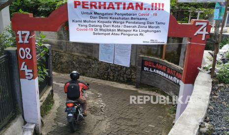 Sebuah tulisan himbauan wajib lapor untuk pendatang dari zona merah Covid-19 dipasang di gerbang masuk salah satu gang di daearah Langensari, Kecamatan Lembang, Kabupaten Bandung Barat, Ahad (5/4). Pembahasan kebijakan mudik terus mengarah kepada larangan yang akan ditetapkan pemerintah. Dirjen Perhubungan Darat Kementerian Perhubungan (Kemenhub) Budi Setiyadi mengaku sudah menyiapkan skenario jika mudik diputuskan akan dilarang tahun ini karena kondisi pandemi virus corona atau Covid-19.