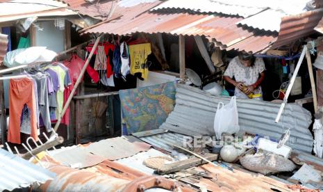 Seorang ibu memasak di rumahnya di kawasan kumuh. ilustrasi