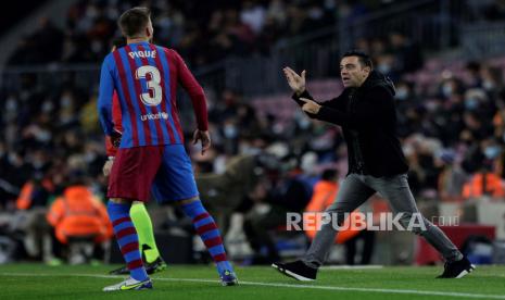 Pelatih kepala FC Barcelona Xavi Hernandez (kanan) dan bek Gerard Pique (kiri) bereaksi saat pertandingan sepak bola LaLiga Spanyol antara FC Barcelona dan RCD Espanyol di Barcelona, Spanyol, beberapa waktu lalu.