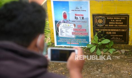 Poster ajakan menerima penjualan tanah terpasang di fasilitas umum  Desa Wadas, Purworejo, Jawa Tengah, Rabu (9/2/2022). Diketahui, pada Selasa (8//2/2022) kemaren 63 orang khususnya 56 warga Wadas ditangkap kepolisian. Para warga yang ditangkap adalah mereka yang bersikeras menolak lahannya dibebaskan untuk penambangan batu adesit. Luas tanah yang akan dibebaskan mencapai 124 hektar.Batu andesit yang ditambang dari Desa Wadas ini sedianya akan digunakan sebagai material untuk pembangunan Waduk Bener yang lokasinya masih berada di Kabupaten Purworejo.