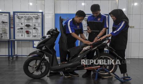 Siswa SMK memeriksa komponen sepeda motor berbahan bakar minyak yang telah dikonversikan ke listrik di Bengkel Kelistrikan TBSM SMKN 8 Kota Bandung, Jalan Kliningan, Lengkong, Kota Bandung, Provinsi Jawa Barat, Selasa (14/2/2023). Siswa kelas XI dan XII jurusan Teknik Bisnis Sepeda Motor (TBSM) mengkonversikan motor berbahan bakar minyak ke tenaga listrik yang diberi nama Matric 8 (Matic Electric). Sepeda motor listrik tersebut memiliki daya 72 volt dan mampu menempuh jarak 50 kilometer hingga 60 kilometer dengan pengisian daya selama lima jam.