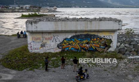 Sejumlah warga beraktivitas di bekas Jembatan Kuning yang ambruk akibat gempa dan tsnuami di Palu, Sulawesi Tengah, Ahad (26/9). Anak usaha PT Wijaya Karya (Persero), PT Wijaya Karya Beton Tbk (Wika Beton) mendapatkan kepercayaan untuk berkontribusi dalam rekonstruksi dan percepatan pembangunan di Sulawesi Tengah