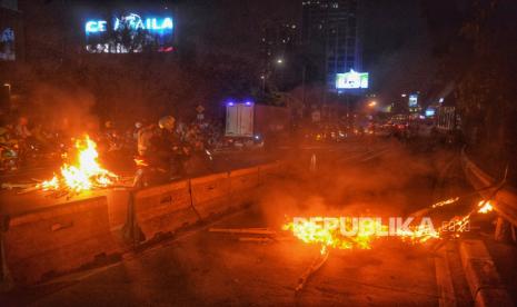 Api yang berasal dari bambu dan plastik yang dibakar oleh massa aksi menolak pengesahan Revisi UU Pilkada berkobar di Fly Over Slipi Petamburan, Jakarta, Kamis (22/8/2024). Aksi pembakaran bambu dan plastik serta upaya menutup jalan raya ini menimbulkan tersendatnya arus lalu lintas di kawasan tersebut.