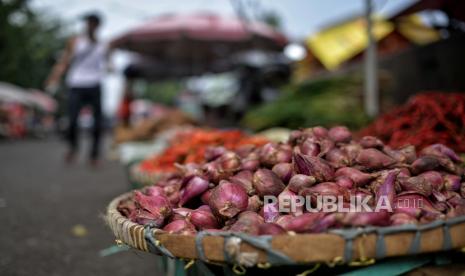 Pedagang menunggu pembeli di pasar tradisional.