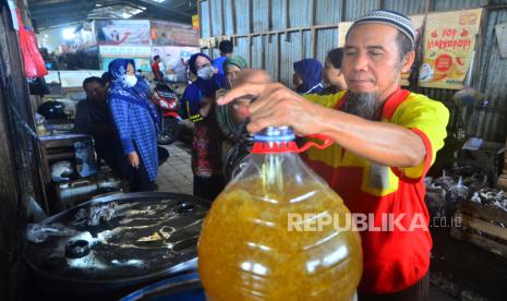 Pedagang melayani pembeli minyak goreng curah di Pasar Bitingan, Kudus, Jawa Tengah, Rabu (23/3/2022). Harga minyak goreng curah di pasar itu mengalami kenaikan dari sebelumnya Rp14 ribu menjadi Rp19000 per liter akibat kurangnya pasokan. 