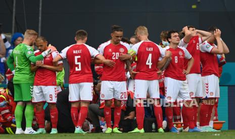 Gelandang timnas Denmark, Christian Eriksen (tengah bawah) menerima bantuan medis setelah dirinya mendadak pingsan pada laga kualifikasi Grup B Piala Eropa melawan Finlandia di Kopenhagen, Denmark, Sabtu (12/6). 