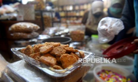 Pedagang melayani membeli makanan ringan dan kue kering di salah satu pusat penjualan kue di pasar Jatinegara, Jakarta.