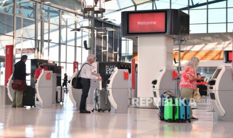 Penumpang melakukan check in untuk penerbangan Qantas Australia, ilustrasi