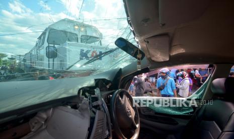 Warga melihat kondisi mobil yang tertabrak Kereta Api (KA) Sibinuang jurusan Naras - Padang di Lubuk Buaya, Padang, Sumatera Barat, Ahad (2/5/2021). Akibat kejadian tersebut pengemudi mobil mengalami luka-luka serta terganggunya jadwal keberangkatan kereta, sementara itu PT KAI Divre II Sumbar mencatat sedikitnya 15 kasus kecelakaan terjadi pada awal 2021 di perlintasan sebidang rel kereta api. 