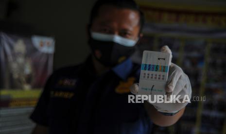 Petugas Kedokteran dan Kesehatan Polrestabes Bandung menunjukan hasil tes urine Anggota Kepolisian saat inspeksi mendadak tes urine di Polsek Sumur Bandung, Bandung, Jawa Barat, Kamis (18/2/2021). Polrestabes Bandung melakukan inspeksi mendadak tes urine kepada anggotanya setelah adanya dugaan kasus penyalahgunaan narkotika oleh Kapolsek Astanaanyar.