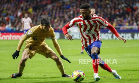 Gelandang Atletico Thomas Lemar (kanan) beraksi melawan gelandang FC Barcelona Pedri (kiri) selama pertandingan sepak bola LaLiga Spanyol antara Atletico de Madrid dan FC Barcelona di stadion Civitas Metropolitano di Madrid, Spanyol, Ahad (08 Januari 2023).