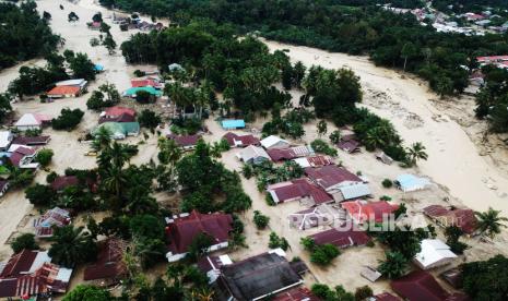 Foto udara kondisi perkampungan tertimbun lumpur akibat terjangan banjir bandang di Desa Radda, Kabupaten Luwu Utara, Sulawesi Selatan, Rabu (15/7/2020). Banjir bandang yang terjadi akibat tingginya curah hujan yang membuat sungai Salukula dan Meli meluap tersebut mengakibatkan 21 orang meninggal dunia dan puluhan warga dilaporkan masih dalam pencarian, sementara  ratusan rumah rusak berat dan hilang tertimbun material lumpur. 