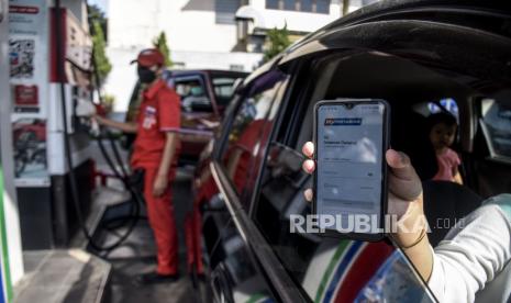 Pengendara kendaraan roda empat menunjukkan aplikasi MyPertamina saat membeli BBM subsidi jenis pertalite di SPBU Pertamina (ilustrasi). 