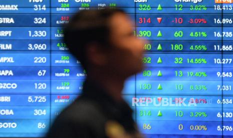 Pekerja berada didekat layar pergerakan Indeks Harga Saham Gabungan (IHSG) usai pembukaan perdagangan Bursa Efek Indonesia (BEI) tahun 2024 di Jakarta, Selasa (2/1/2024). 