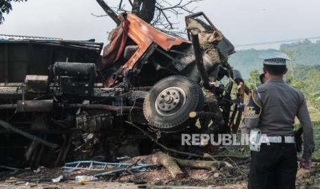 Petugas kepolisian mengamankan lokasi kecelakaan truk di Gekbrong, Kabupaten Cianjur, Jawa Barat, Jumat (12/7/2024).Kecelakaan lalu lintas memiliki kontribusi cukup besar terhadap angka kemiskinan.