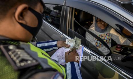 Pelanggar Ganjil-Genap Berkurang Sejak Tilang Diberlakukan. Anggota kepolisian saat menilang pengendara mobil dengan nomor plat ganjil di kawasan Fatmawati, Jakarta, Senin (10/8). Direktorat Lalu Lintas Polda Metro Jaya kembali menerapkan sanksi tilang terhadap kendaraan roda empat yang melanggar peraturan ganjil genap di masa Pembatasan Sosial Berskala Besar (PSBB) transisi. Republika/Putra M. Akbar