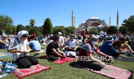 Sholat di Hagia Sophia, Gereja Yunani Kompak Berkabung. Orang-orang menunggu sholat Jumat pertama selama upacara pembukaan resmi Hagia Sophia sebagai masjid di Istanbul, Turki, 24 Juli 2020. Presiden Turki Recep Tayyip Erdogan akan menghadiri salat Jumat pertama. Pengadilan administrasi tertinggi Turki pada 10 Juli memutuskan bahwa museum yang dulunya masjid yang dibangun di Katedral akan diubah menjadi masjid lagi dengan membatalkan statusnya sebagai museum.