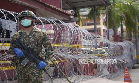 Seorang tentara bersenjata berjaga di luar area perumahan kepadatan tinggi yang ditempatkan di bawah perintah kontrol gerakan yang ditingkatkan (EMCO) karena peningkatan drastis jumlah kasus COVID-19 yang tercatat di Sunway, di pinggiran Kuala Lumpur, Malaysia, Jumat, 2 Juli , 2021. 