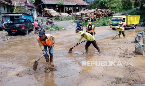 Petugas melakukan pembersihan material sisa longsor yang berdampak terhadap ruas jalan Garut-Tasikmalaya di wilayah Desa Tenjowaringin, Kecamatan Salawu, Kabupaten Tasikmalaya, Jawa Barat, Kamis (23/3/2023). 