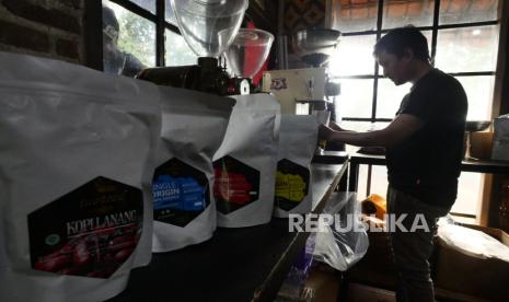 Seorang pekerja menggiling biji kopi di gerai Kopi Puntang di kawasan Cimaung, Bandung, Kamis (21/9/2023).