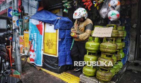 Warga berjalan didekat tabung gas LPG 3 Kg yang kosong di salah satu warung kelontong di Kawasan Tebet, Jakarta, Kamis (6/2/2025).