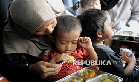 Sejumlah orang tua mendampingi anak balitanya menyantap hidangan makan bergizi gratis (MBG) di Posyandu Dahlia, Ciracas, Jakarta, Jumat (10/1/2025). 