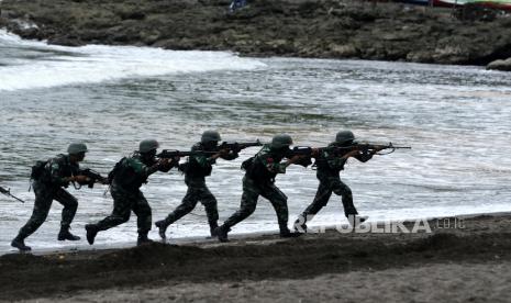 Prajurit Raider Batalyon Infanteri (Yonif) Satuan Jajaran Divisi 2 Kostrad beraksi saat simulasi pembebasan sandera pada penutupan latihan pembentukan Raider tahun 2021 di Pantai Grajagan, Banyuwangi, Jawa Timur, Senin (29/11/2021). Sebanyak 500 prajurit TNI AD lulus kualifikasi Raider setelah menempuh latihan selama dua bulan. 