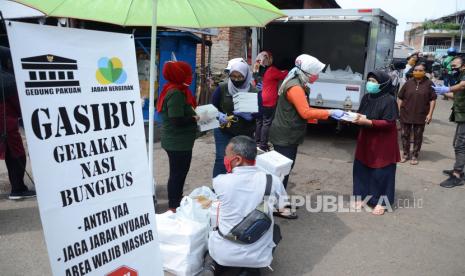 Bersama para relawan, Ketua Umum Jabar Bergerak Atalia Kamil memimpin pembagian nasi bungkus dan masker gratis untuk masyarakat dalam Gerakan Nasi Bungkus (Gasibu) di Terminal Dago, Jl Ir H Djuanda, Kota Bandung, Ahad (19/4). Kegiatan tersebut untuk membantu masyarakat yang terdampak Covid-19