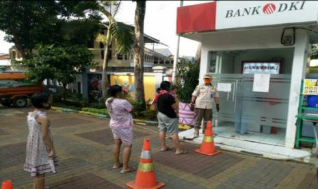 Nasabah yang ingin mencairkan dana KJP tetap menjaga jarak fisik minimal 1 meter di ATM Bank DKI